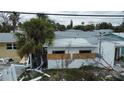 House with storm damage and plywood covering windows at 14236 Palm St, Madeira Beach, FL 33708