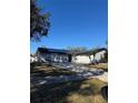 Gray house with black roof, driveway, and landscaping at 15906 Country Farm Pl, Tampa, FL 33624