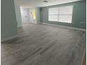 Bright living room with light gray vinyl flooring and pale walls at 2048 Tumbleweed Dr, Holiday, FL 34690