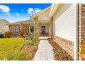 Front entrance with walkway, landscaping, and blue door at 2249 Grandfather Mtn, Spring Hill, FL 34606