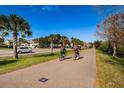 Residents enjoying the bike path in this community with lush landscaping at 2353 Hanover Dr, Dunedin, FL 34698