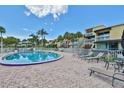Community pool area surrounded by lounge chairs and lush tropical landscaping under a sunny sky at 2424 W Tampa Bay Blvd # B201, Tampa, FL 33607