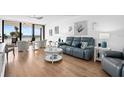 Bright living room with ocean view, comfy seating, and hardwood floors at 3820 Gulf Blvd # 203, St Pete Beach, FL 33706