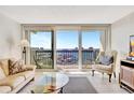 Open living room with balcony access showcases water views and comfortable seating arrangement at 400 Island Way # 1404, Clearwater Beach, FL 33767