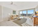 Bright living room featuring neutral tile flooring, comfortable sofa and water views from a private balcony at 400 Island Way # 1404, Clearwater Beach, FL 33767