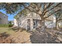 Backyard featuring a screened patio with a mature tree providing shade and privacy at 5038 White Sanderling Ct, Tampa, FL 33619