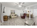 Open floor plan of living room with ceiling fan, gray floors, comfortable seating, and dining area at 5328 Ridgewell Ct, Tampa, FL 33624