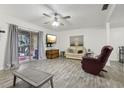 Living room featuring sliding glass doors, gray floors, ceiling fan, and comfortable seating at 5328 Ridgewell Ct, Tampa, FL 33624