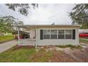White house with black shutters, carport, and small yard at 723 Ornelda Sw St, Ruskin, FL 33570