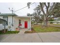 Side entrance with covered porch and red door at 723 Ornelda Sw St, Ruskin, FL 33570