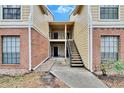 Attractive two-story condo building with brick and siding exterior, stairs, and landscaping at 8647 Fancy Finch Dr # 203, Tampa, FL 33614