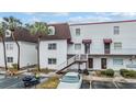 Two-story condo building with a brown roof and white exterior at 9119 Tudor Dr # E201, Tampa, FL 33615