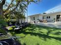 Expansive backyard with artificial turf, wooden chairs, and a deck at 1041 Eldorado Ave, Clearwater Beach, FL 33767