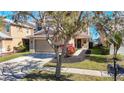 Tan two-story house with a two-car garage and manicured lawn at 11616 Crest Creek Dr, Riverview, FL 33569