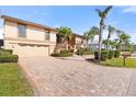 Two-story house with a double garage and palm trees at 127 6Th E St, Tierra Verde, FL 33715