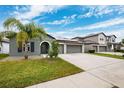 Two story house with palm trees and a three car garage at 13580 Willow Bluestar Loop, Riverview, FL 33579