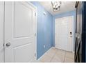 Bright entryway with light blue walls, tile flooring, and white doors at 17071 Oval Rum Dr, Wimauma, FL 33598