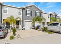 Two story townhome with gray siding, two car garage, and palm trees at 34395 Sorrel Mint Dr, Wesley Chapel, FL 33543