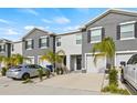 Two story townhome with gray siding, two car garage, and palm trees at 34395 Sorrel Mint Dr, Wesley Chapel, FL 33543