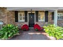 Front entrance with black door and poinsettias at 4307 W Kensington Ave, Tampa, FL 33629