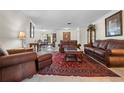 Spacious living room featuring brown leather furniture and a red rug at 4606 Ridgecliff Dr, Brandon, FL 33511