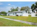 One-story home with white exterior, gray accents, and a fenced backyard at 5127 Chatsworth Ave, Tampa, FL 33625