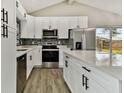 Modern kitchen with white cabinets, stainless steel appliances, and a quartz island at 516 Highview N Cir, Brandon, FL 33510