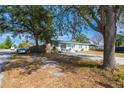 Exterior view of a light blue house with mature trees and a driveway at 5481 65Th N Ave, Pinellas Park, FL 33781