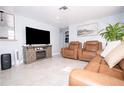 Living room with brown leather furniture and a large TV at 5481 65Th N Ave, Pinellas Park, FL 33781