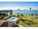 Community pool with water view and lush landscaping at 100 Oakmont Ln # 602, Belleair, FL 33756