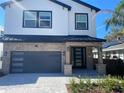 Modern two-story house with gray garage and landscaped front yard at 1046 Bass Blvd, Dunedin, FL 34698