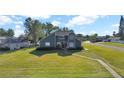 Two-story house with gray siding, red door, and landscaped yard at 11201 Lake Sassa Dr, Thonotosassa, FL 33592