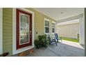 Inviting covered porch with decorative front door, seating, and manicured landscaping at 11540 Balintore Dr, Riverview, FL 33579