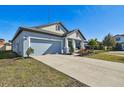 Newly built home with light blue exterior, landscaping, and a two-car garage at 12119 Creek Preserve Dr, Riverview, FL 33579