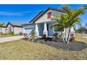 Newly built home with light blue exterior, landscaping, and a two-car garage at 12119 Creek Preserve Dr, Riverview, FL 33579