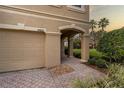 Attached garage with a tan exterior and paved pathway at 17533 Stinchar Dr, Land O Lakes, FL 34638