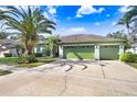 Single-story house with a three-car garage and a lush green lawn at 2005 Wexford Green Dr, Valrico, FL 33594