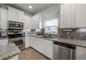 Modern kitchen with white cabinets, granite counters, and stainless steel appliances at 2291 Bolzano Ct, Land O Lakes, FL 34639