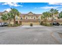 Attractive tan townhome with two-car garage and palm trees at 2648 Tanglewood Trl, Palm Harbor, FL 34685