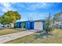 Blue ranch home with a single car garage and mature landscaping at 4308 Craftsbury Dr, New Port Richey, FL 34652