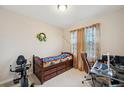 Bright bedroom with a built-in desk, chair, and exercise equipment at 954 Old Windsor Way, Spring Hill, FL 34609