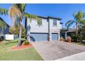 Two-story house with gray siding, stone accents, and a two-car garage at 12405 Crestridge Loop, New Port Richey, FL 34655