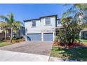 Two-story house with gray siding, stone accents, and a two-car garage at 12405 Crestridge Loop, New Port Richey, FL 34655