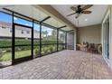 Enjoy indoor/outdoor living on the screened patio with brick pavers and ceiling fan at 1264 Riserva Ln, Palm Harbor, FL 34683