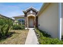 Stone and tan house with walkway to the front door and landscaping at 14638 Strathglass Dr, Hudson, FL 34667