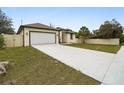 Newly built home with a white garage door and long concrete driveway at 15958 Adobe Dr, Hudson, FL 34667