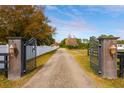 Open wrought iron gates with stone pillars and pathway at 18029 Lake Reflections Blvd, Lutz, FL 33558