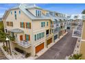 Aerial view of a row of townhouses with attached garages and metal roofs at 19915 Gulf Blvd # 303, Indian Shores, FL 33785