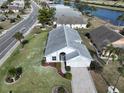 House with a grey roof, paved driveway and green lawn at 243 Linger Ln, Sun City Center, FL 33573