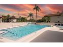 Community swimming pool with lounge chairs and palm trees at 2750 E Bay Dr # 1E, Largo, FL 33771